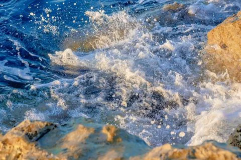 Waves crushing on the rocks on beach in the morning time. Sunrise on the wavy Stock Photos