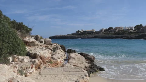 Waves crushing on a sandy beach with rocky hills. Stock Footage 122444236