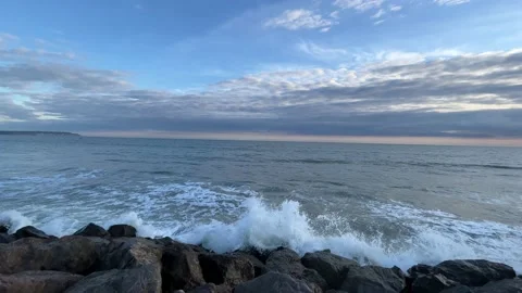 Waves crushing on the shore on a sunset - pan Video stock 211884034