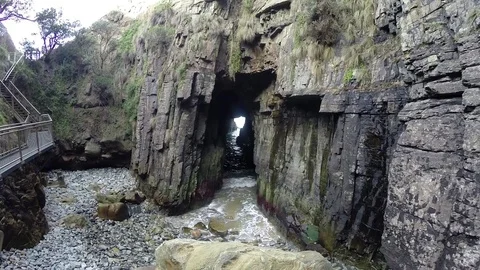 Waves crushing through rock tunnel Stock Footage 71966506