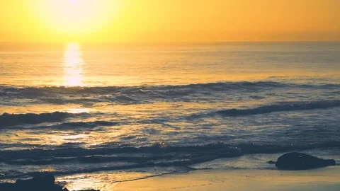 Waves during deep yellow sunset with water reflections, Carcavelos beach, Por Stock Footage 108923648