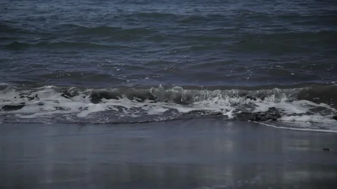 Waves ebb and flow on a dark sandy beach Stock Footage 90958999