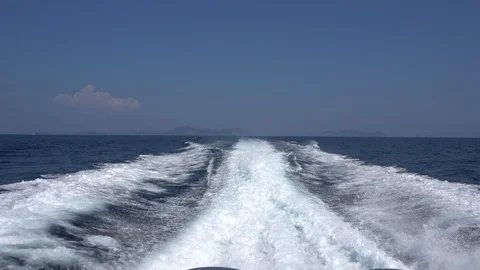 Waves from the engines of a high-speed boat. Rear view. Blue sky, white cloud. 스톡 동영상 106966521