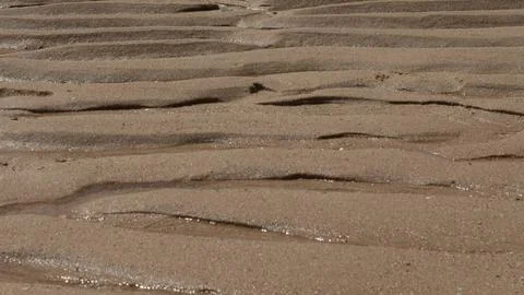 Waves etch patterns on Albufeira beach Stock Photos