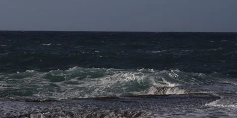 Waves exploding in foam on a rocky ledge Stock Footage 59525132