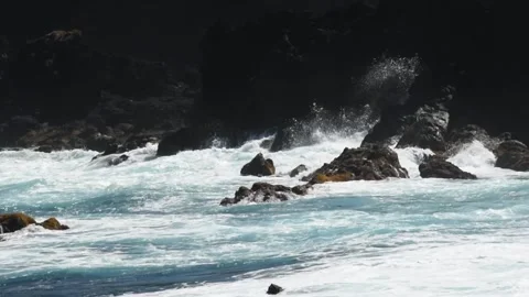 Waves exploding over black lava rocks below a dark sea cliff, Mosteiros, Sao Vídeos de archivo 344532057