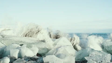 Waves exploding over ice blocks on a beach in Iceland slow motion Vídeos de archivo 348026503