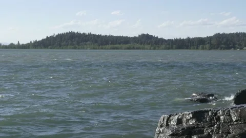 Waves On Flathead Lake Splashing Onto Rocks With Mountains In Background Video stock 204108654