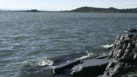 Waves On Flathead Lake Splashing Onto Rocks With Mountains In Background Video stock 204108747