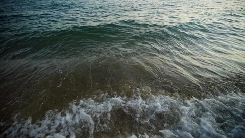 Waves floating on the sandy shore Stockbeeldmateriaal 213078022