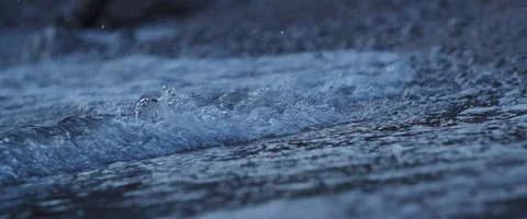 Waves flow on a beach at night, blue hour in the evening in slowmotion Video stock 97901105