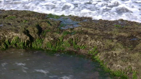 Waves flow over rock formations, creating little waterfalls (High Definition) Stock Footage 65575