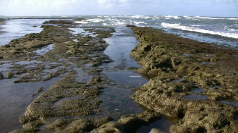 Waves flow over rock formations, creating little waterfalls (High Definition) Stock Footage 65577