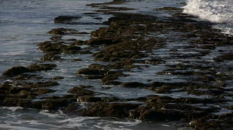 Waves flow over rock formations, creating little waterfalls (High Definition) Stock Footage 65579