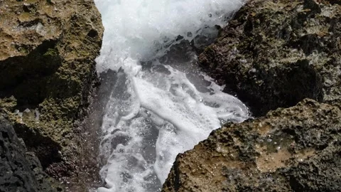 Waves flowing through rock crevice Cala Blava Mallorca in 4K 스톡 동영상 333479228