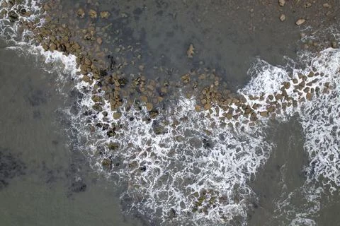 Waves flowing/crashing on a rocky beach Stock Photos