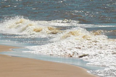 Waves with foam on the beach Stock Photos