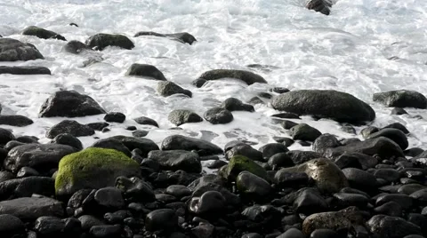 Waves folding down on stones on a beach Stock Footage 49319243