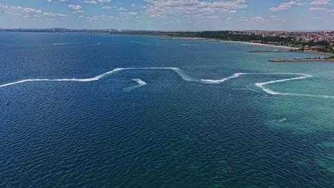 Waves form patterns in the ocean near a coastal city on a sunny day Stock Footage 339652914