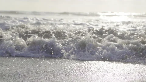 Waves frothing at the beach against the sunset Stock Footage 167867435