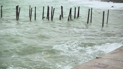 Waves with garbage are broken on a concrete slab on the shore Stock Footage 82125689