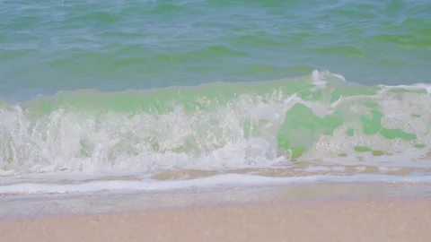 Waves gently caress the sandy beach under the bright summer sky by the tran.. Stock Footage 264026596