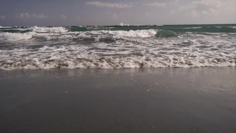 Waves gently crash on the sandy beach shore, a serene seaside atmosphere Video stock 278159020
