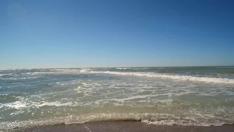 WAVES GENTLY CRASHING ON BEACH WITH BLUE SKY BACKGROUND, STATIC SHOT Stock Footage 72632055