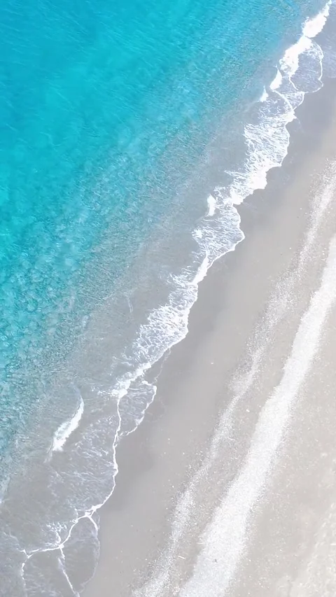 Waves Gently Crashing on a Sandy Beach in a Tropical Paradise During a Sunny Day Stock Footage 317750636