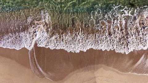Waves gently lap against the sandy shore, creating a serene moment on a quiet Stock Footage 331259302