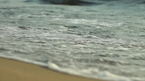 Waves gently lap the sandy shores of the Baltic Sea during sunset view Video stock 311865966