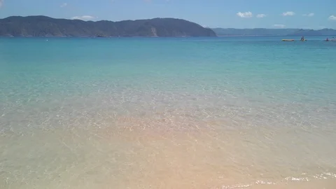Waves gently lap at the shoreline on a pristine tropical beach Stock Footage 125111737