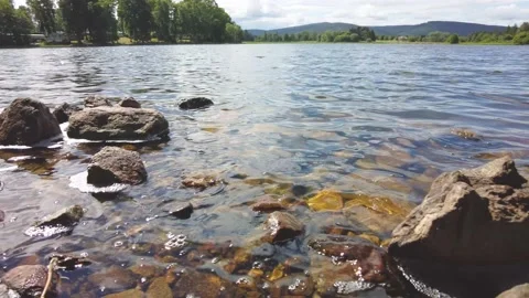 Waves gently lapping the rocky shore of Aboyne Loch Video stock 201269831