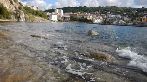 Waves gently lapping the sandstone cliff of agropoli promontory italy 4314 Stock Footage 107399566
