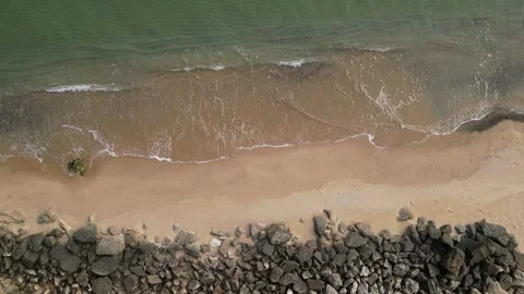 Waves gently roll onto a sandy beach at a tranquil coastal location Stock Footage 296088866