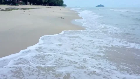 Waves gently roll onto the sandy beach on a tropical island Stock-Footage 312391120