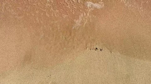 The waves gently roll onto the sandy beach, gradually writing the word "summer"  Stock Footage 332324393