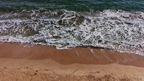 Waves gently roll onto the sandy shore in a coastal landscape Stock Footage 325720833
