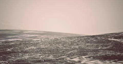 Waves gently rolling on a misty ocean at sunrise over tranquil waters Illustrazione stock