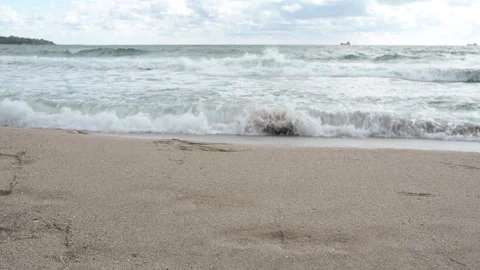 Waves gently rolling onto a sandy beach with natural ocean sound, creating a Stock Footage 319570659