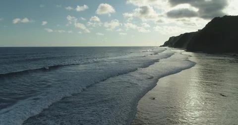 Waves gently rolling on the shore of Bali, Indonesia at sunset Stockfoto's