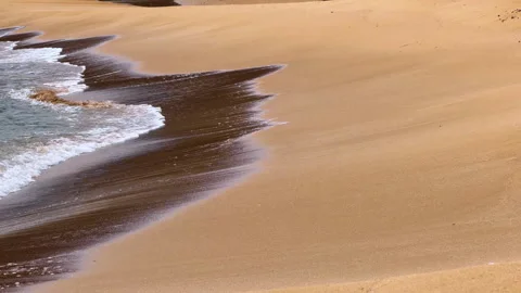 Waves gently touch the sandy shore on a sunny beach in the afternoon. Waves roll Stock Footage 327158513