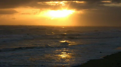 Waves gently wash up onto beach at sunrise (High Definition) Stock Footage