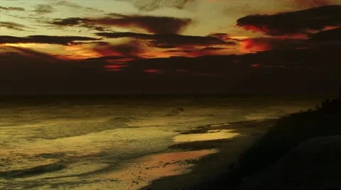 Waves gently wash up onto the beach at sunset Stock Footage 10885635