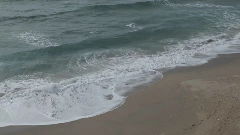 Waves gently washing onto a sandy beach shoreline. Stock Footage 296197176