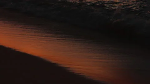 Waves gliding onto the beach at sunset in 4K Stock Footage 41699439