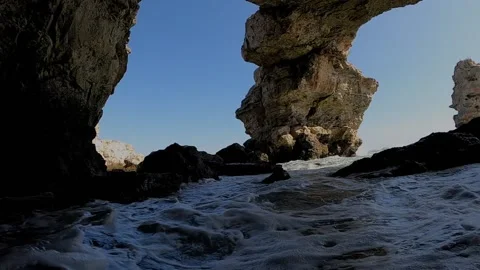 Waves going under rocky arc Stock Footage 148514730