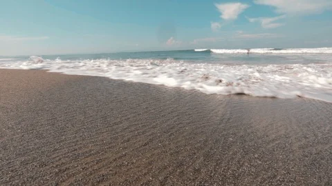 Waves hit the beach sand in Bali - Handheld camera Stock Footage 112882559