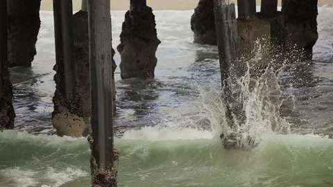 Waves hit bottom of pier slow motion Stock Footage 152599852