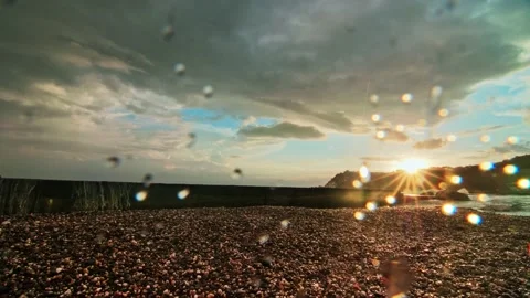 The waves hit the pier and raise a splash up, in the frame the sun over the Stock Footage 218404204